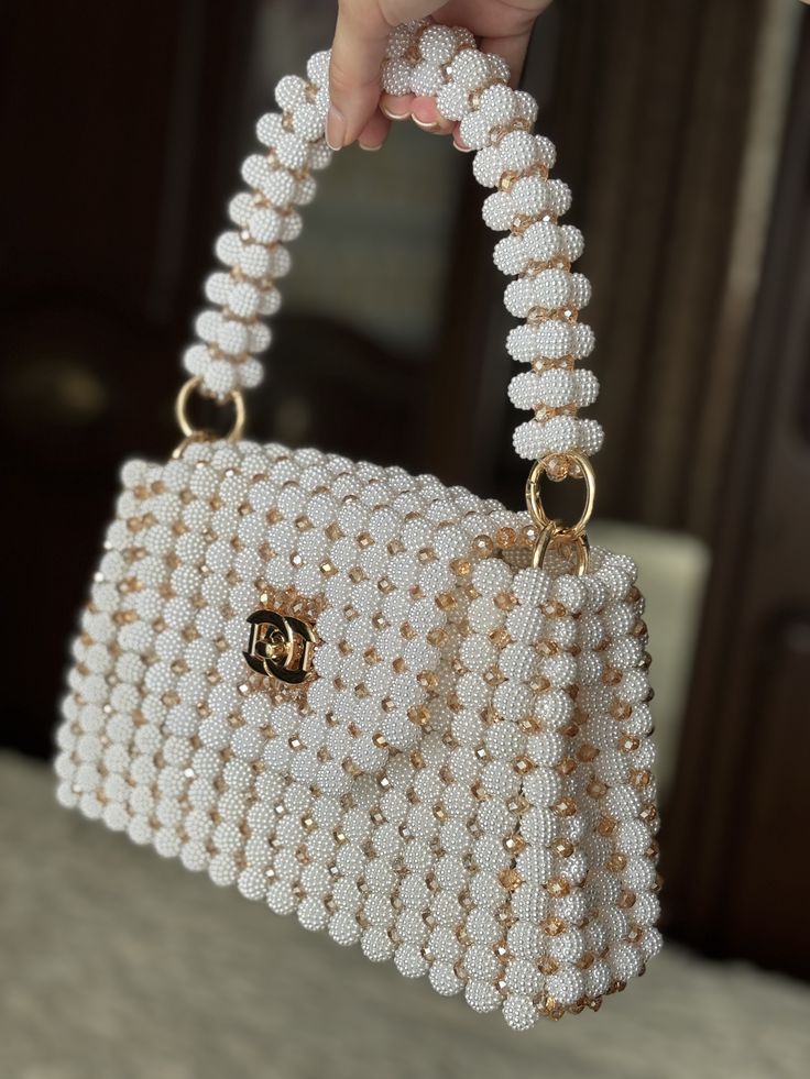Bolso de cuentas color perla sostenido por una mujer